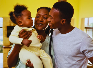A nurturing family cherishes moments at home with their cute black baby, creating a loving and supportive bond.