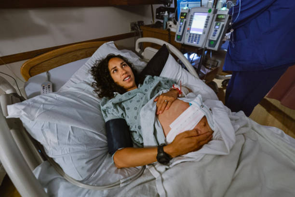 Pregnant woman having contractions at the hospital while discussing the option of an elective C-section.