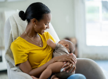 A black woman breastfeeding her baby, showing the exclusive breastfeeding advantages of bonding, nutrition, and immunity support