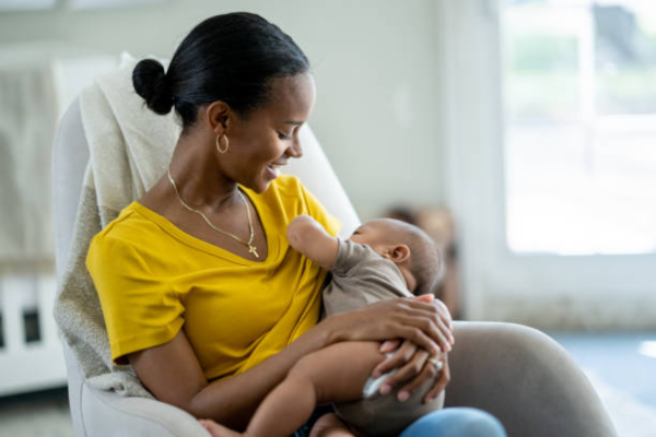 A black woman breastfeeding her baby, showing the exclusive breastfeeding advantages of bonding, nutrition, and immunity support