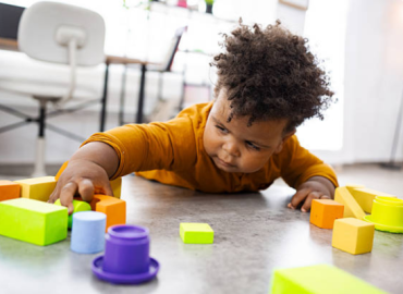 Early Signs of Autism in Toddlers Understanding, Diagnosis & Support Early Signs of Autism: A toddler gently playing alone with toys, showing typical solitary play behavior