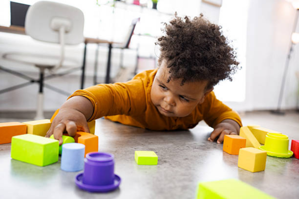 Early Signs of Autism: A toddler gently playing alone with toys, showing typical solitary play behavior