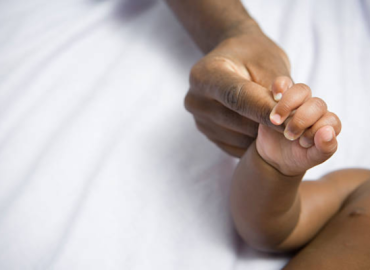 Newborn Care Tips Your Essential Guide for the First Months African American newborn baby and mom holding hands, symbolizing love and bonding. Essential Newborn Care Tips for first-time parents