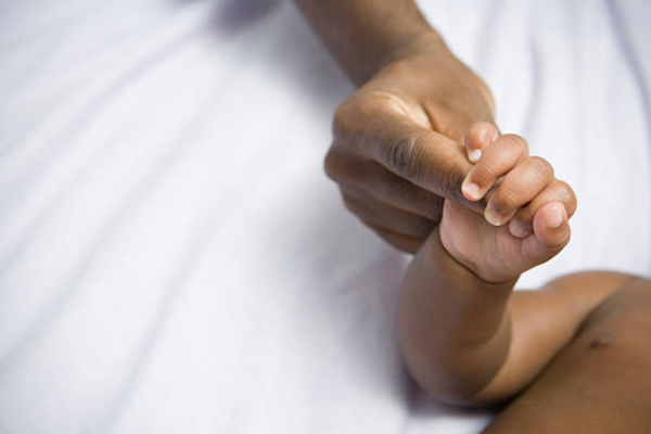 African American newborn baby and mom holding hands, symbolizing love and bonding. Essential Newborn Care Tips for first-time parents